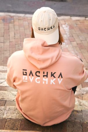 Personne de dos portant un sweat à capuche et une casquette avec des inscriptions GACHKA.