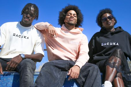 Trois personnes portant des sweats avec le mot «&nbsp;GACHKA" sur fond de ciel bleu.